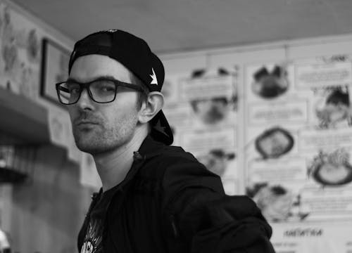 Black and White Photo of a Man in a Baseball Cap 