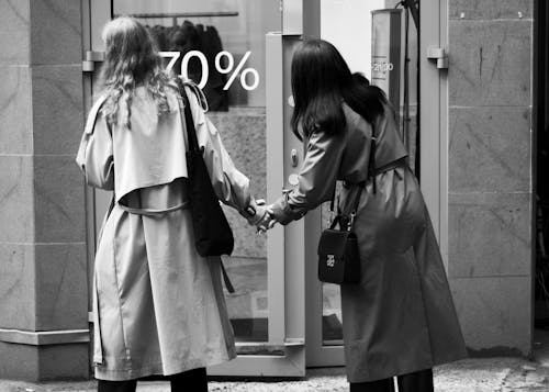 Women in Coats Standing in Front of Store Window