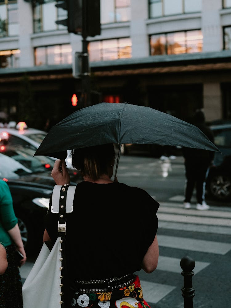 Photo Of A Woman Walking By The Crosswalk With A Black Umbrella