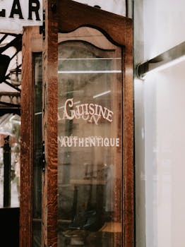 A rustic wooden door with 'Cuisine Authentique' sign marks the entrance to a French restaurant.
