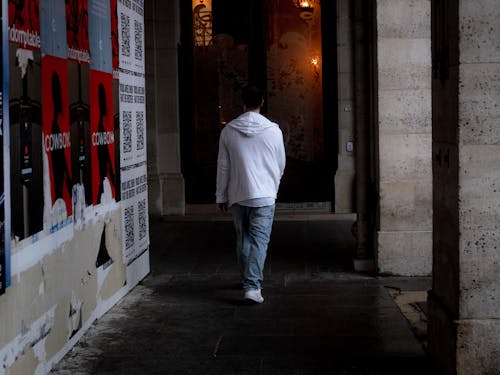 Man in White Hoodie Walking on the Hallway