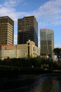 Contemporary high-rise buildings against a clear sky in an urban setting, featuring modern architecture.