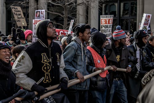 Free People in Black and Red Jacket Standing on Street Stock Photo