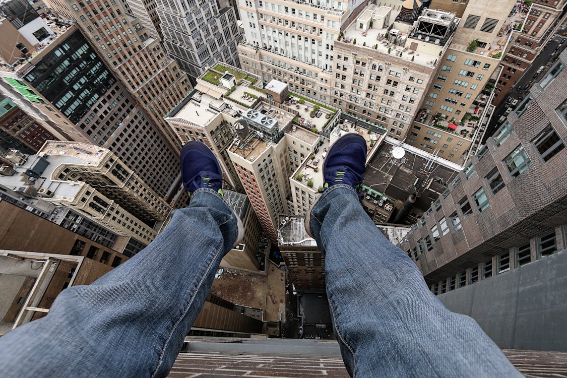 Person Sitting on the Edge of a Building