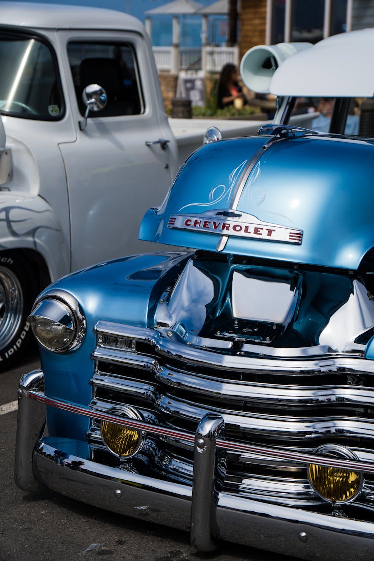 Blue Chevrolet Car Parked Beside White Pickup Truck