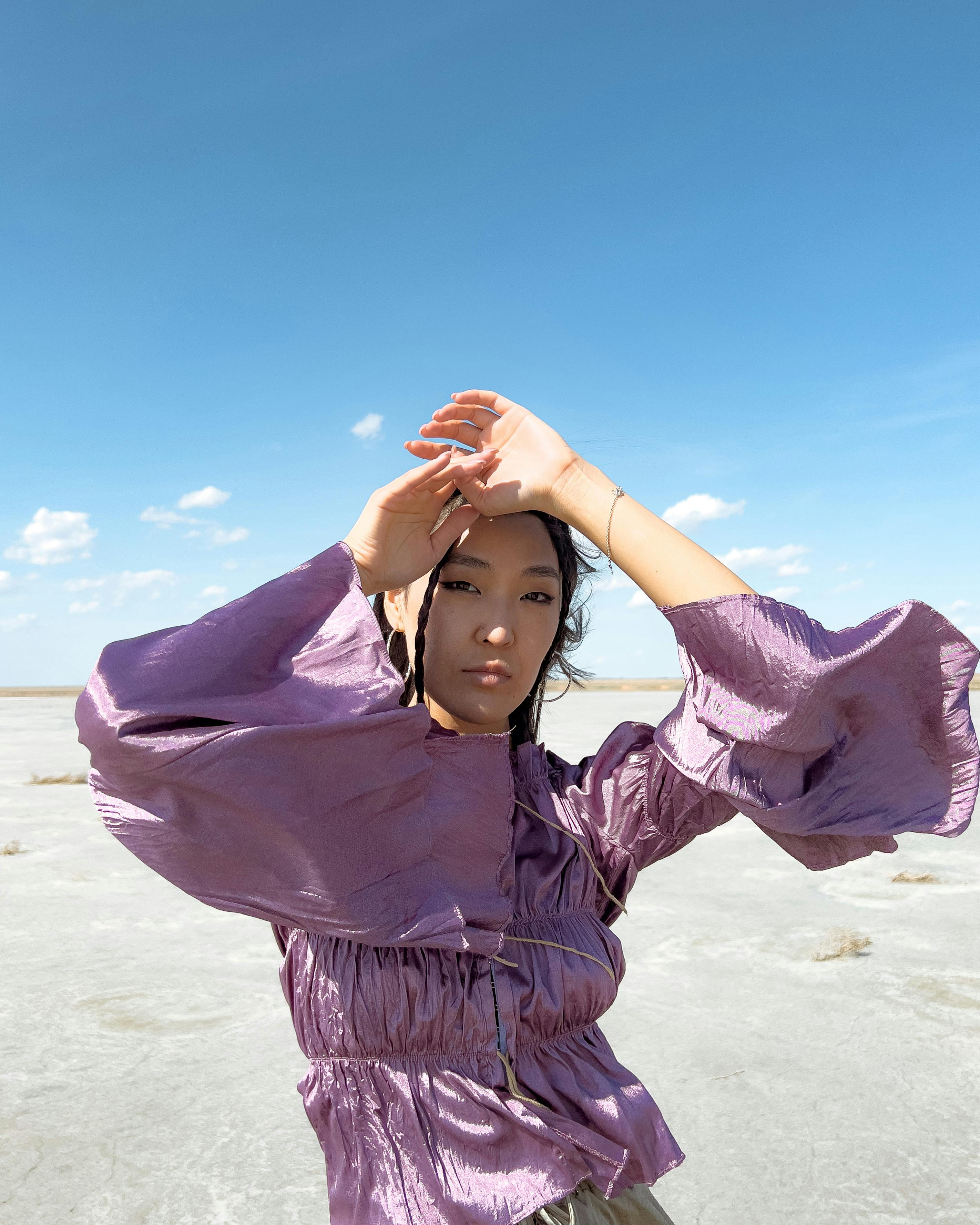 attractive girl in violet blouse with arms raised