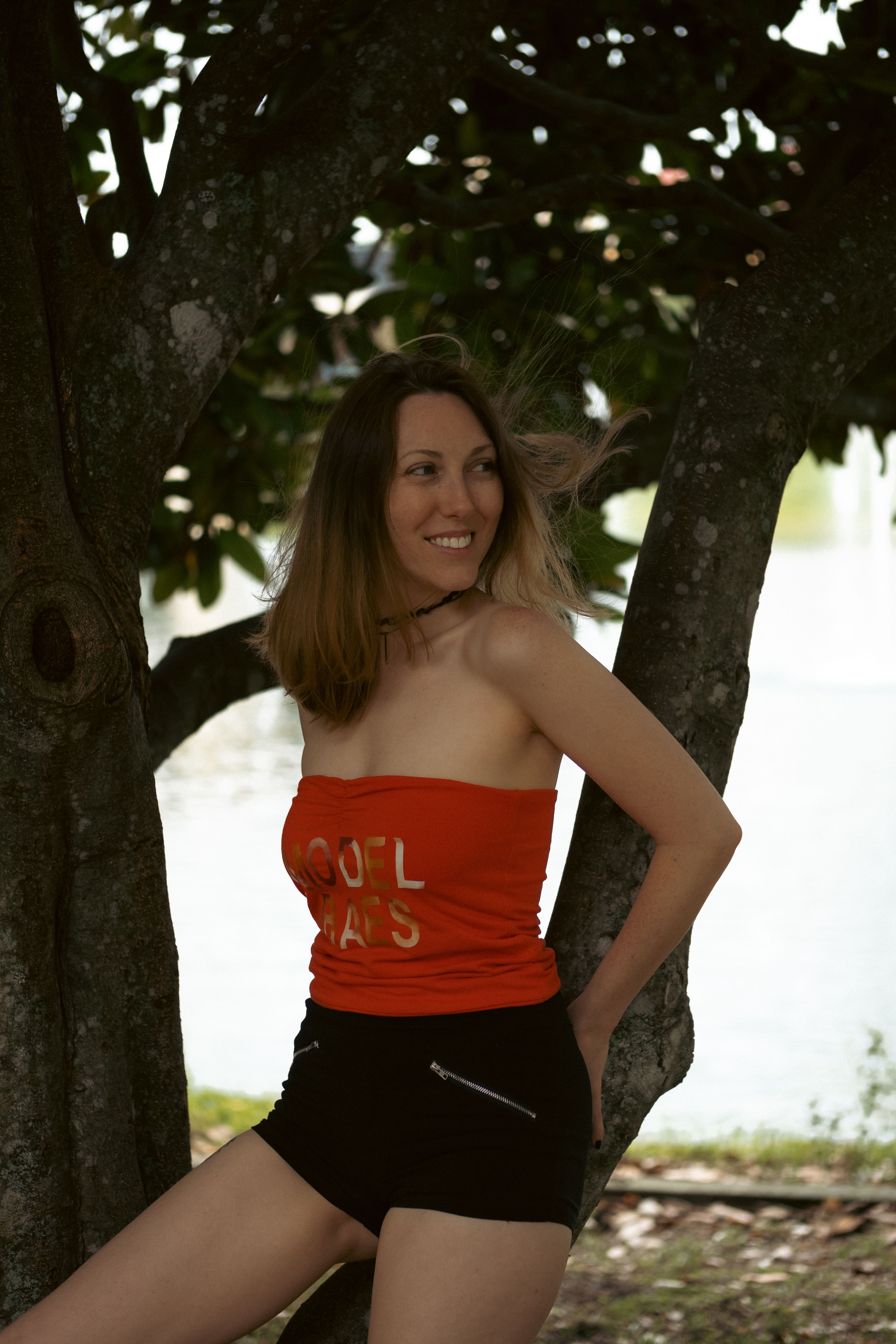 Brunette Woman in Red Top Posing Under Tree · Free Stock Photo