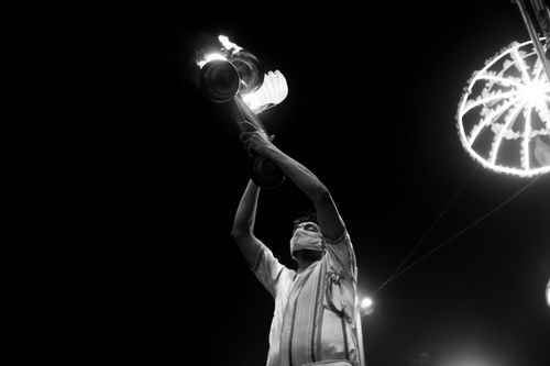 Free A man in traditional attire performs a fire ritual in Varanasi, India at night, under vibrant lights. Stock Photo