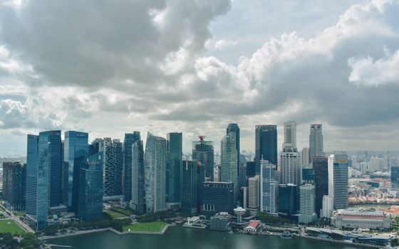 A stunning aerial view of Singapore's skyscrapers under dramatic clouds.
