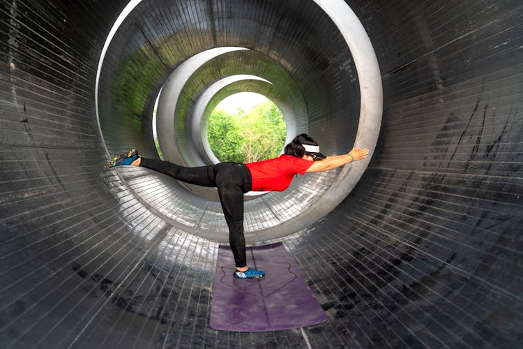 A Woman Exercising In A Concrete Pipe