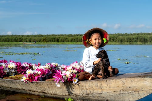 A Girl Sitting with a Dog on a Boat