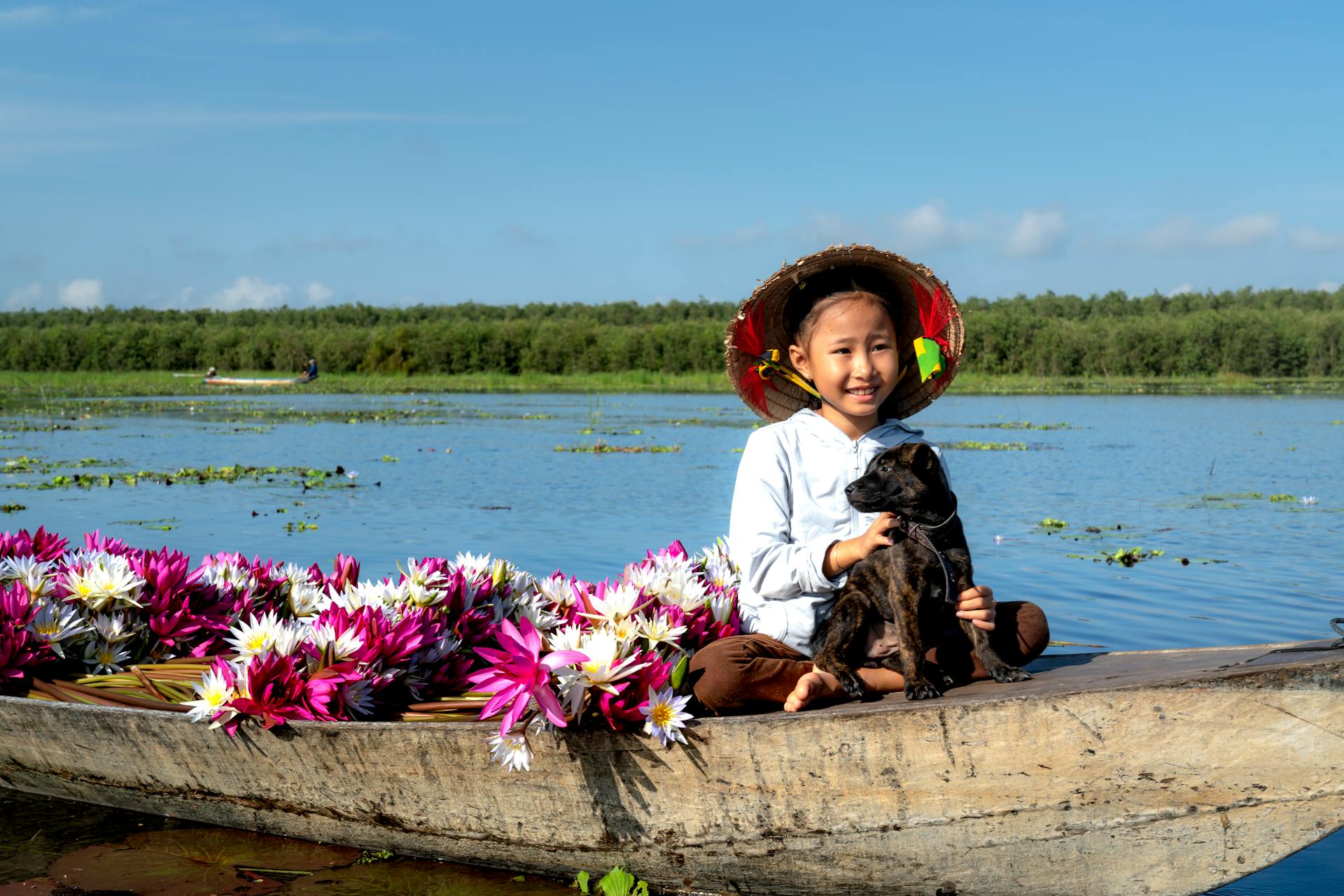 A Girl Sitting with a Dog on a Boat