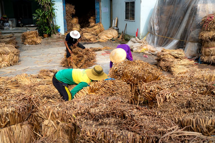 People Working With Hay Bundles