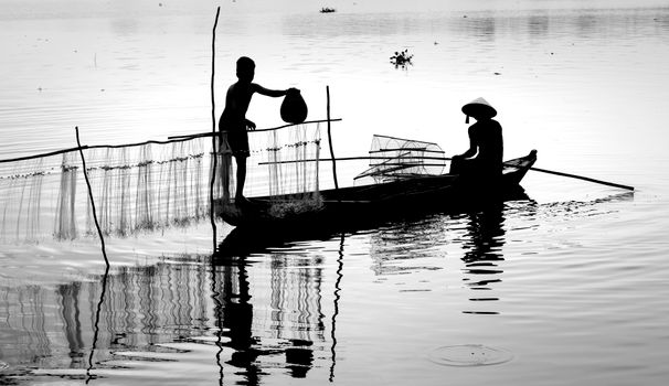 A black and white silhouette of fishermen working with nets on a tranquil river.