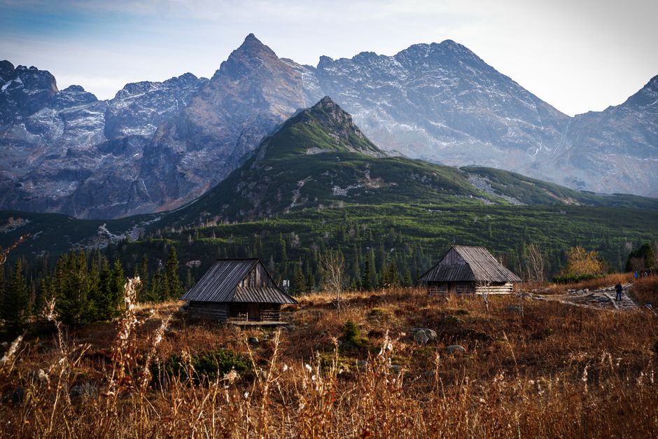 A stunning mountain landscape with wooden huts set against a majestic backdrop.