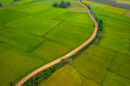 Aerial Photography of Moving Cars on the Road Between Farm Field