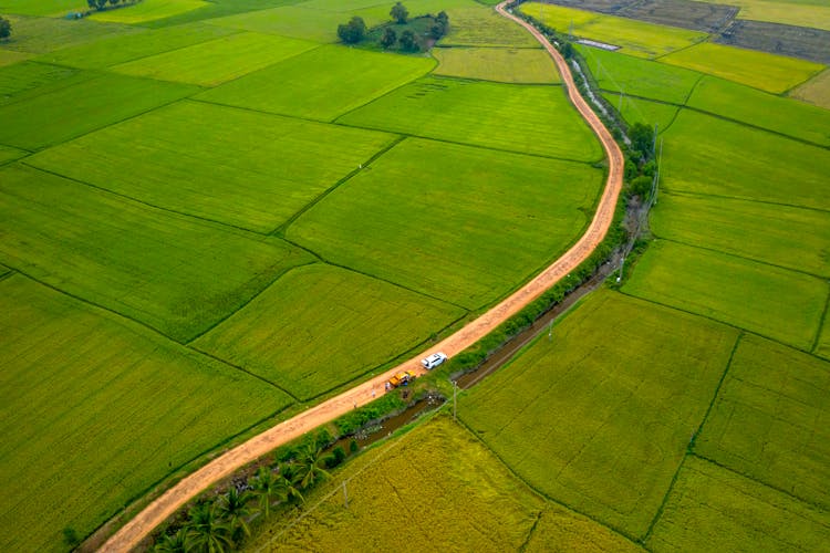 Aerial Photography Of Moving Cars On The Road Between Farm Field