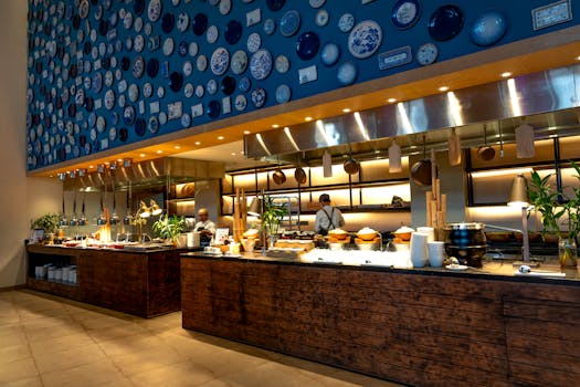 Modern restaurant interior featuring a stylish bar counter and artistic plate wall design.