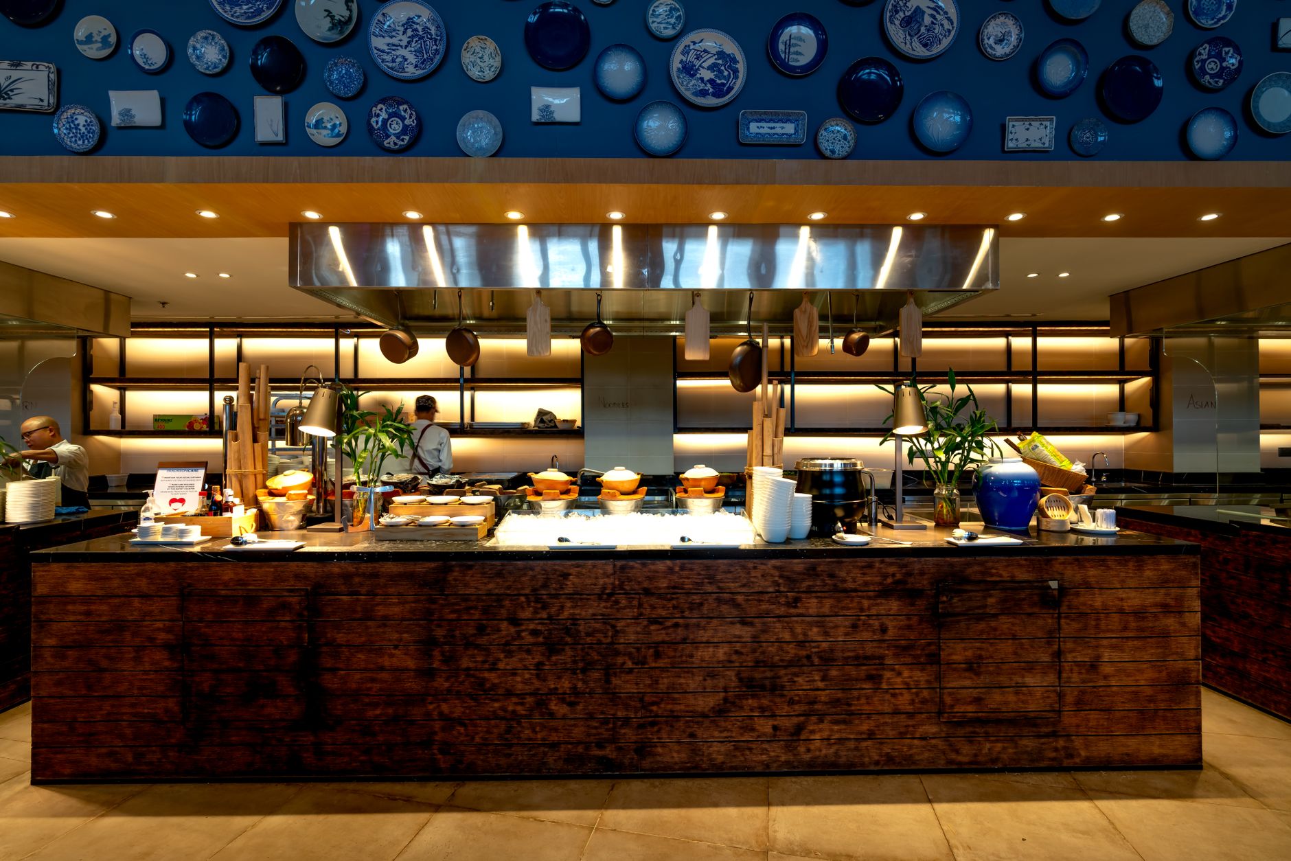 Modern restaurant kitchen with vibrant wall decor and wooden countertops.
