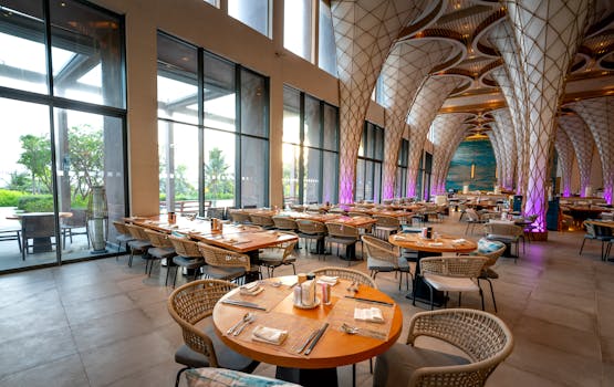 Luxurious restaurant dining area with artistic architecture and empty tables.