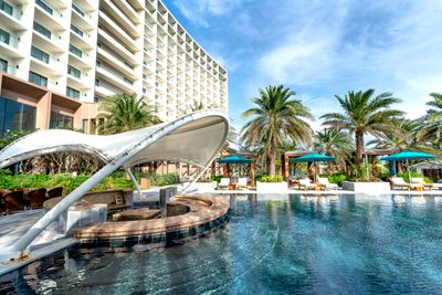 Resort pool with cabanas and palm trees, photo by Quang Nguyen Vinh on Pexels