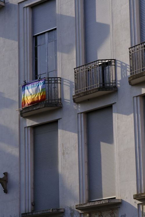 Free A rainbow flag hangs from a balcony on a building in Toulouse, France. Stock Photo