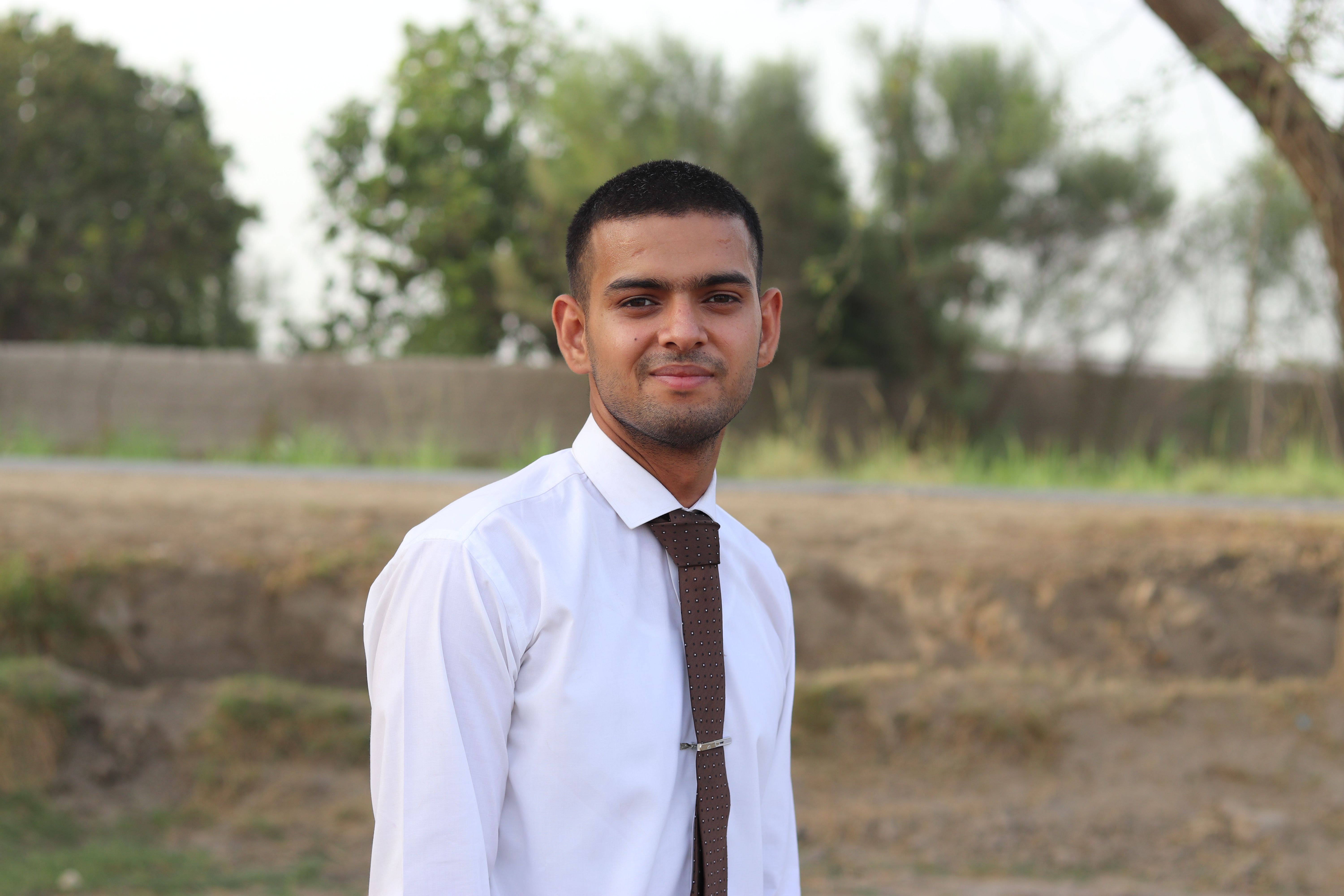 Portrait of a young man wearing a tie outdoors, exuding confidence and style.