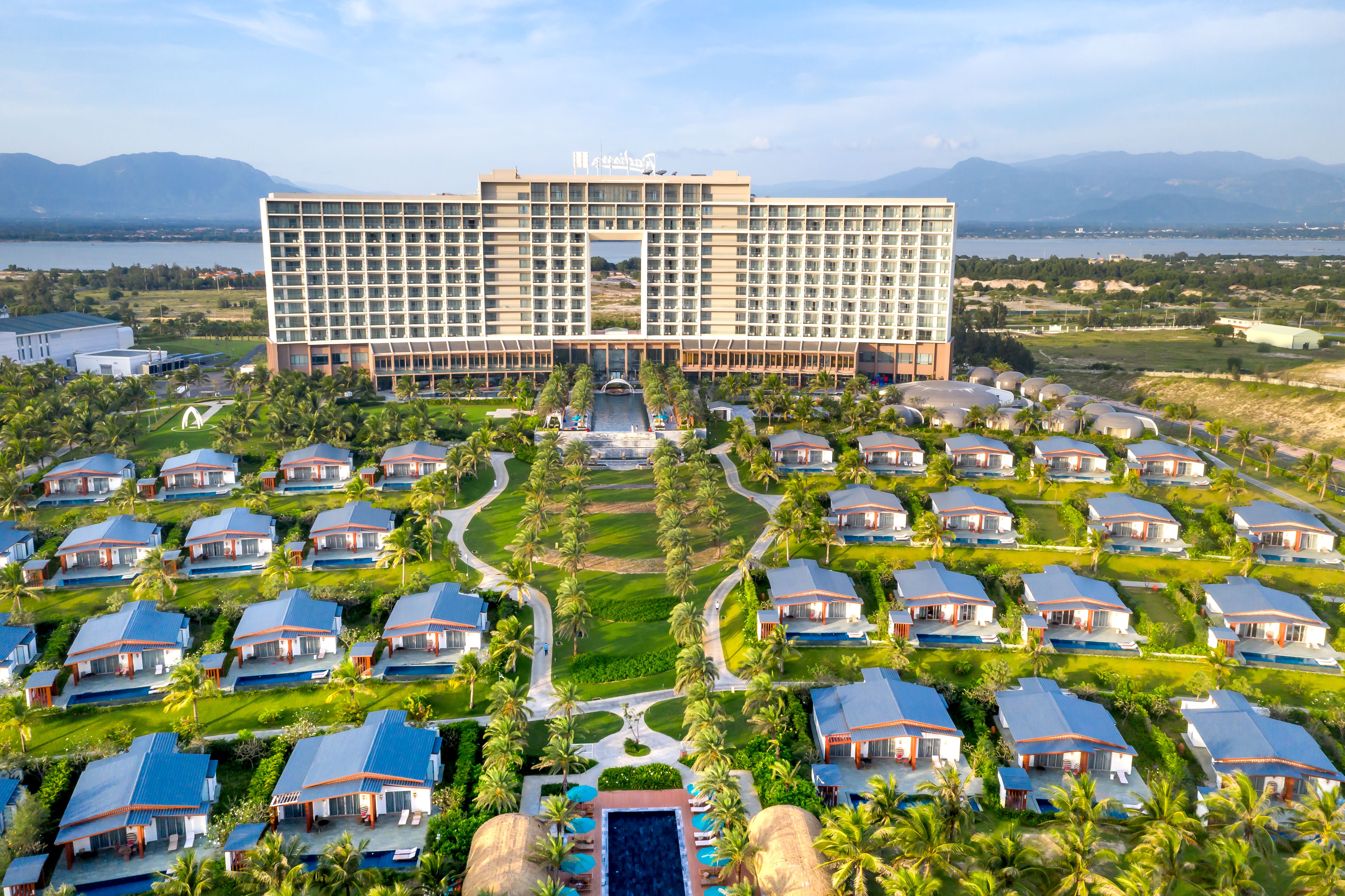 A breathtaking aerial shot of a luxury resort featuring villas, palm trees, and scenic landscapes.