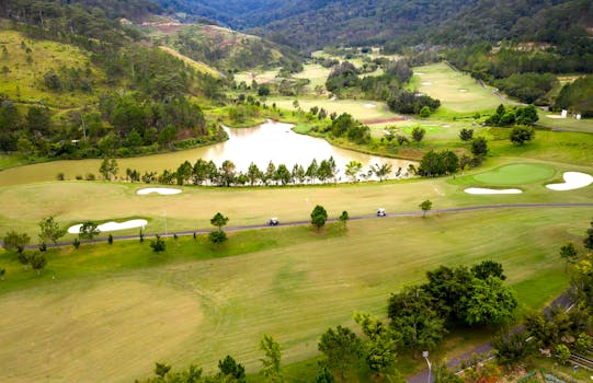 Explore a beautiful golf course from above, surrounded by lush greens and rolling hills.