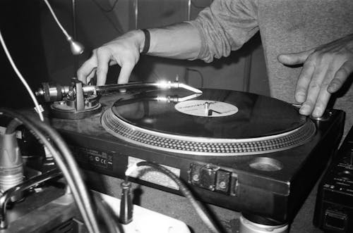 Fotografía En Escala De Grises De Una Persona Tocando El Tocadiscos