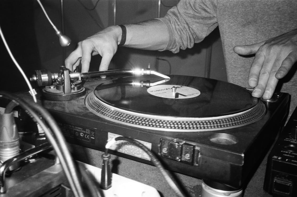 Free Grayscale Photography of Person Playing Turntable Stock Photo