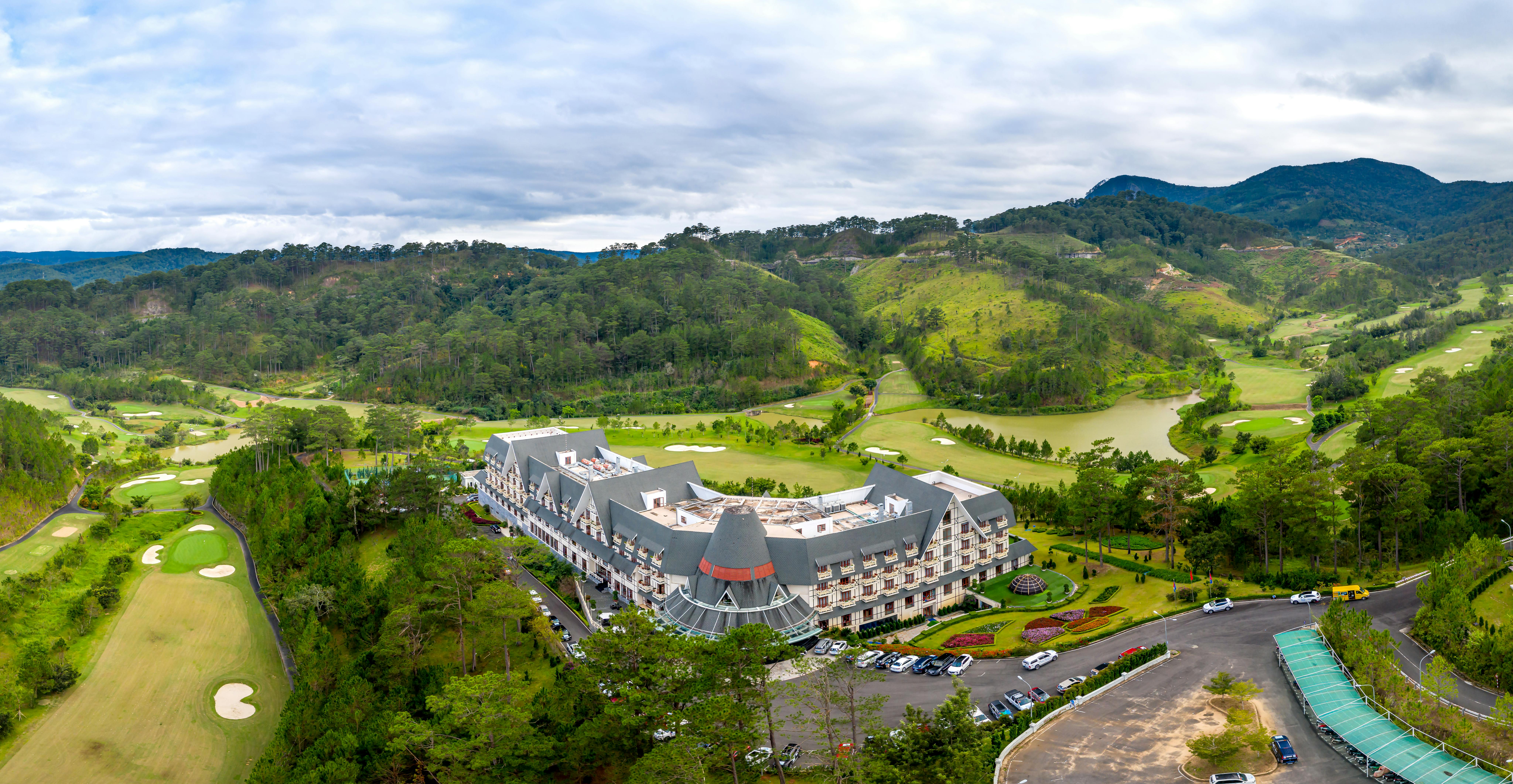 Stunning aerial shot of a resort in a lush, mountainous landscape with golf course.