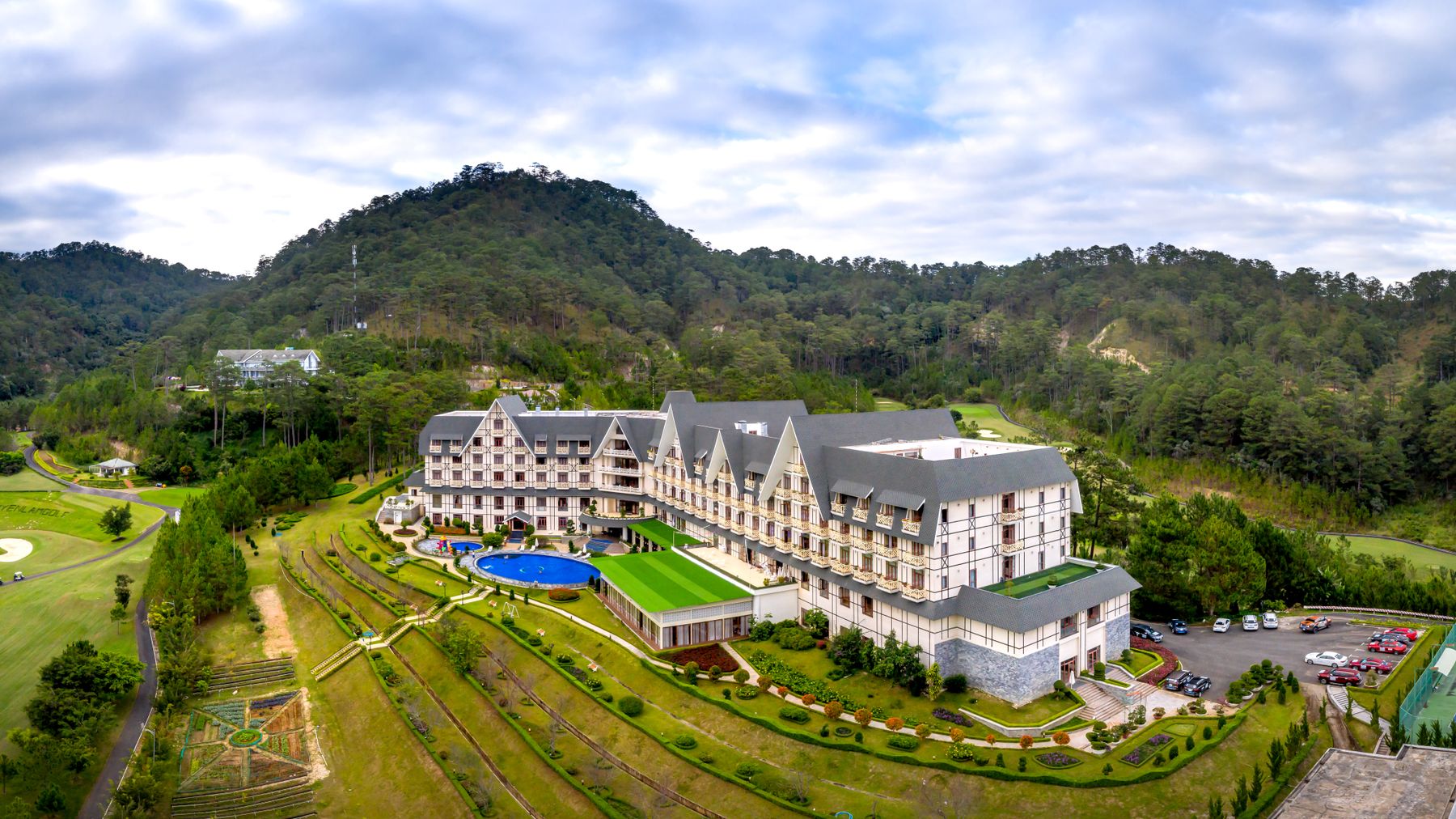 Scenic aerial photo of a luxury hotel surrounded by lush mountains.