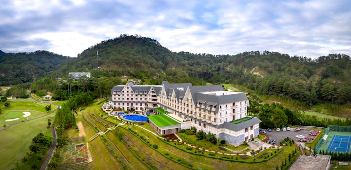 Scenic aerial photo of a luxury hotel surrounded by lush mountains.