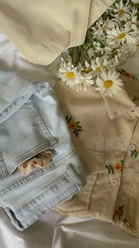 Stylish combination of denim, floral patterns, and daisies on a soft surface.