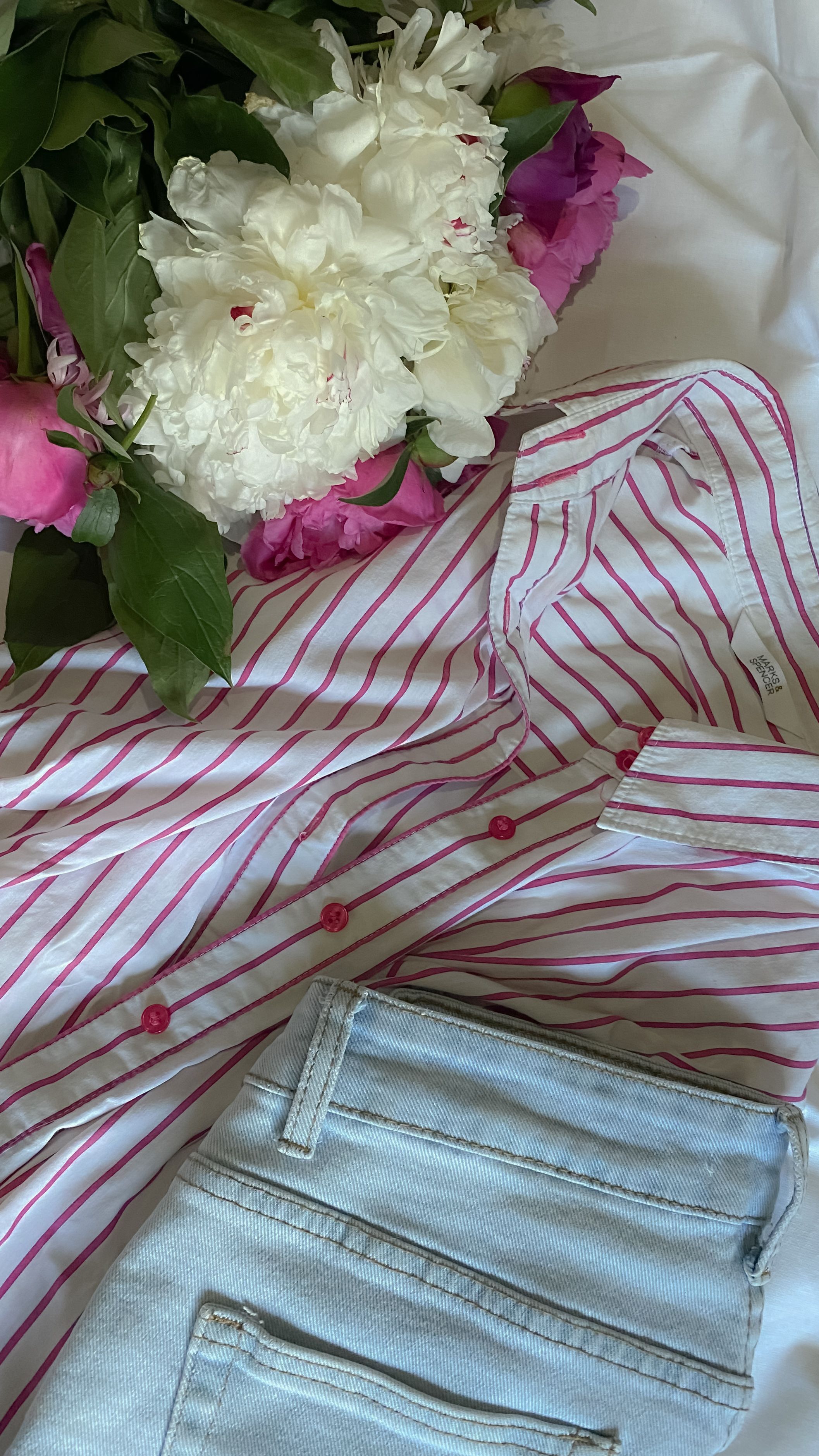 Striped shirt denim and flowers arranged in a fashion flat lay without people