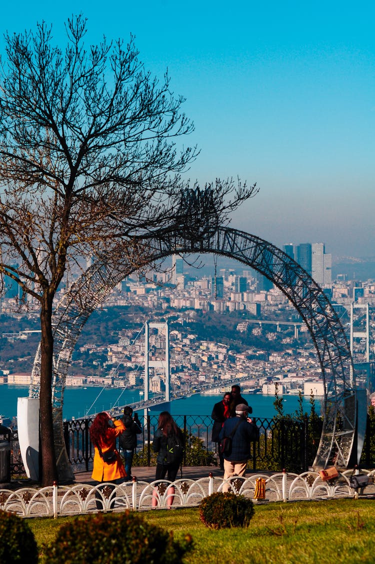 People In A Park Overlooking The City Skyline 