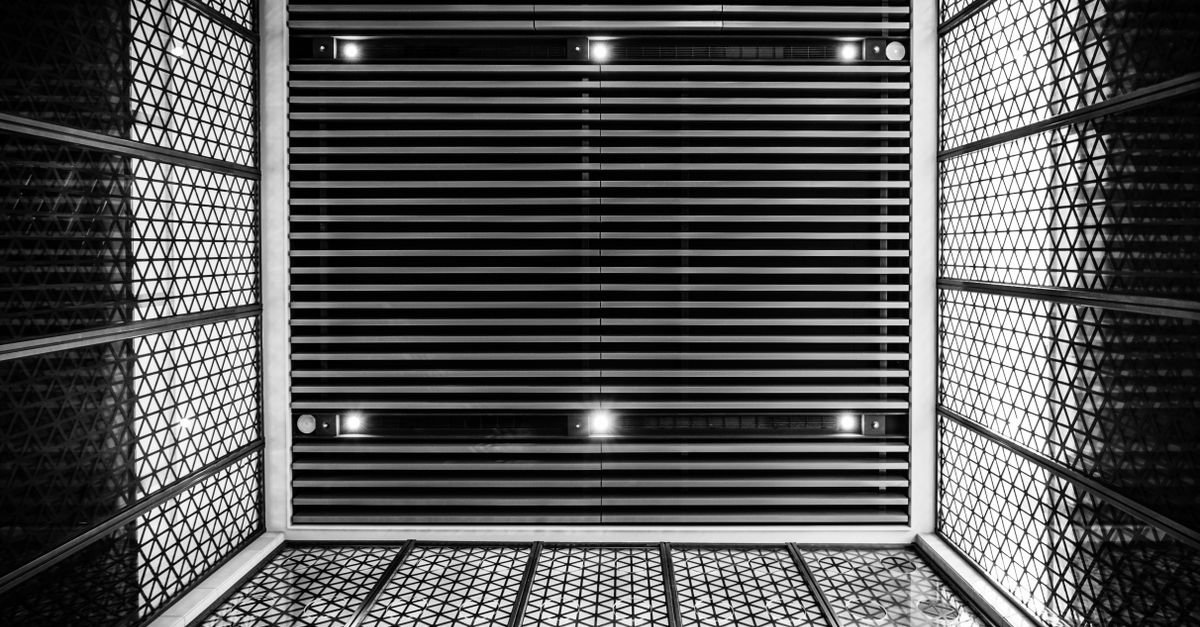 Imagem em preto e branco de um teto arquitetônico geométrico com padrões intrincados.