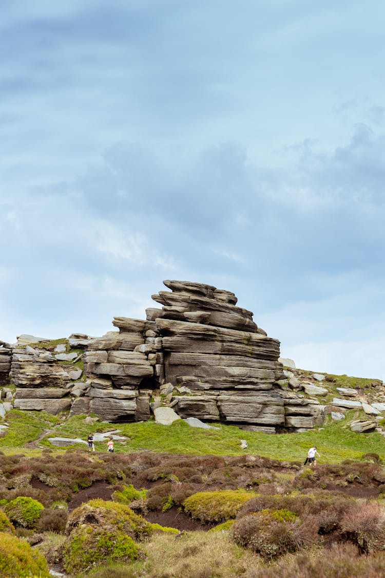 Stacked Rock Formation Under White Clouds