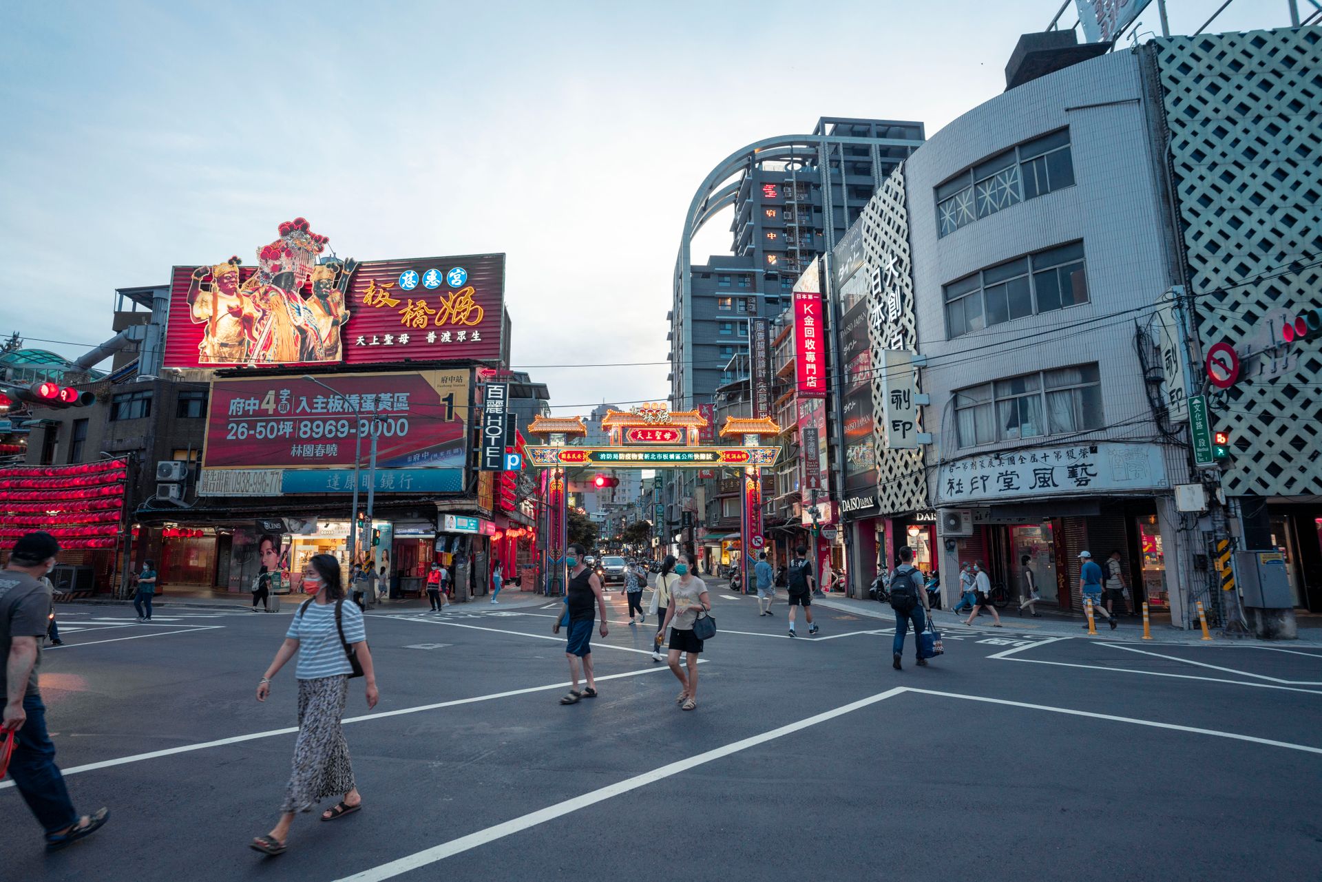 Dynamic street view of Taipei's bustling downtown showcasing neon signs and busy pedestrian activity at dusk.