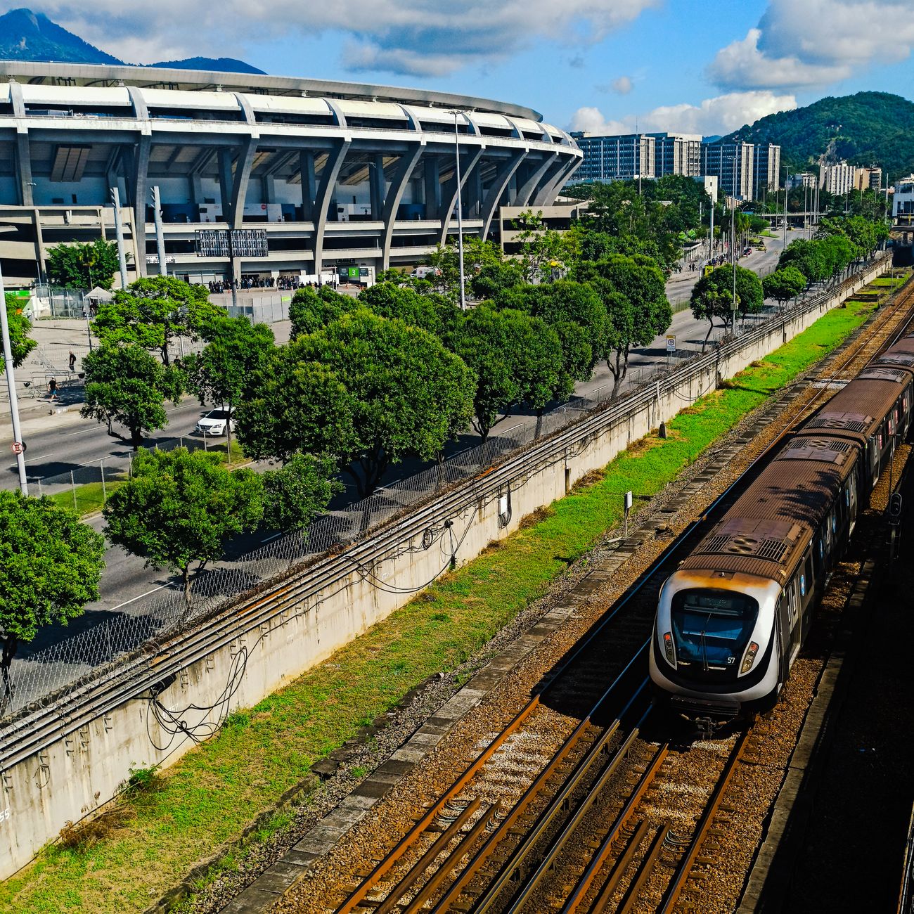 High-angle view of a train approaching Maracanã Stadium in Rio de Janeiro, Brazil, with clear skies.