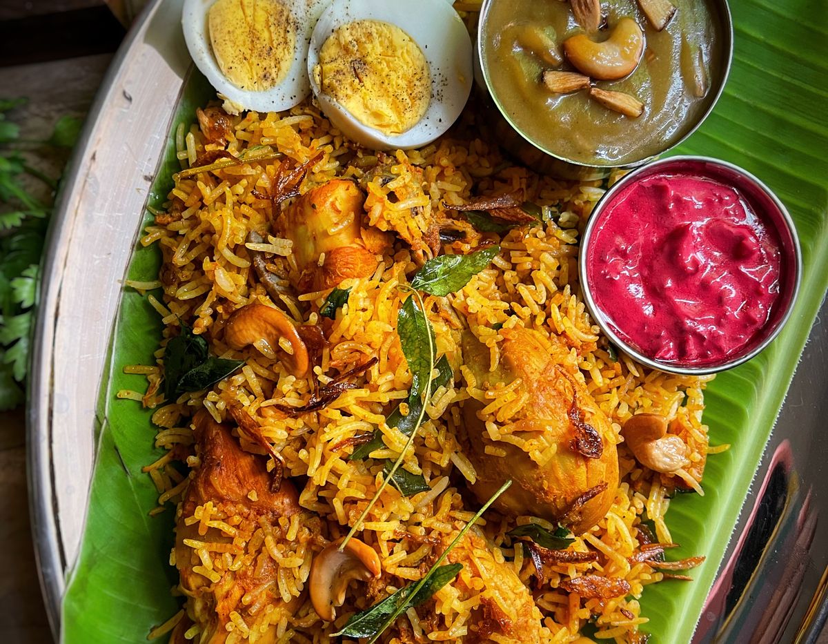 Biryani with side dishes on a banana leaf