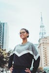 Free женщина в черно сером свитере с круглым вырезом возле здания днем Stock Photo