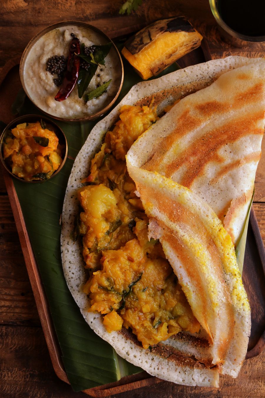 Close-up of crispy masala dosa with coconut chutney and sambar