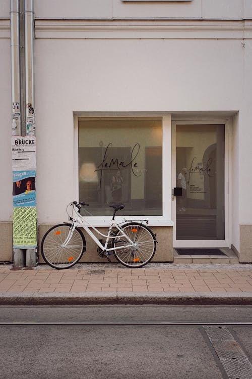 Free White Bicycle Parked Beside White Concrete Building Stock Photo