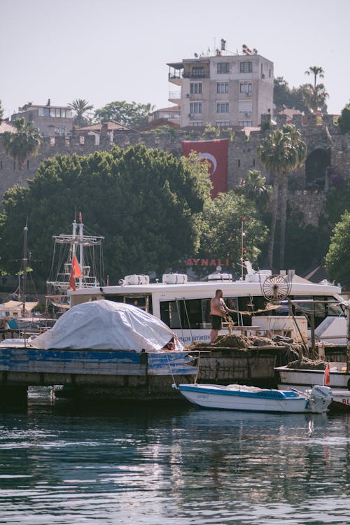 Man Standing on the Dock Near Boats on Water 