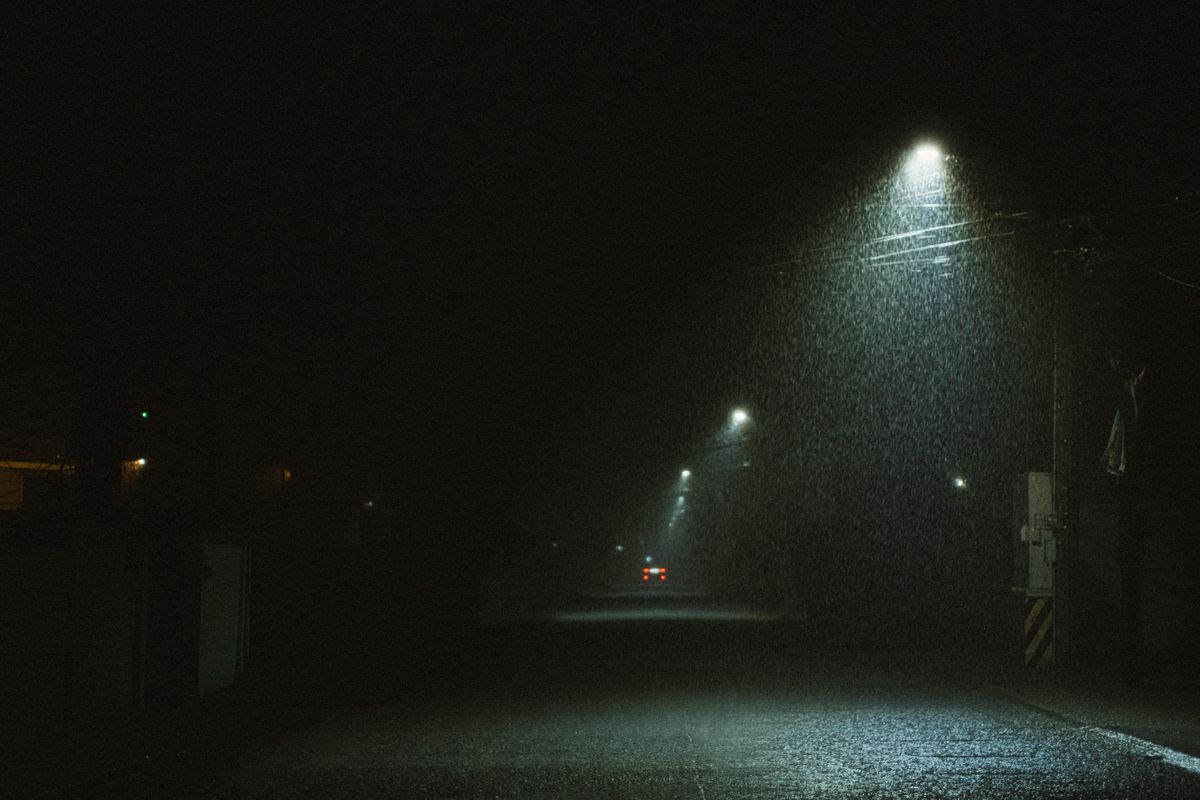 夜の激しい雨に照らされた道路