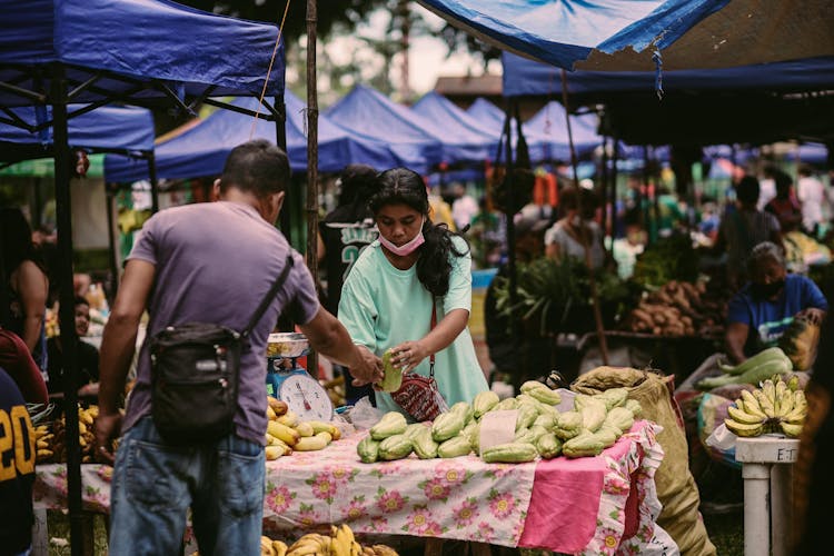 Man Buying Vegetables From Street Vendor