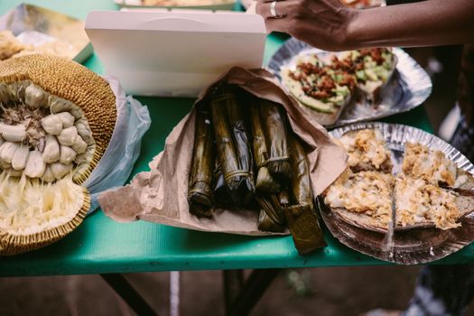 A variety of traditional Filipino delicacies and a sliced jackfruit on a table, offering a taste of tropical flavors.