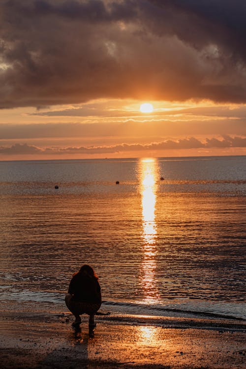 A Person on the Shore during Sunset